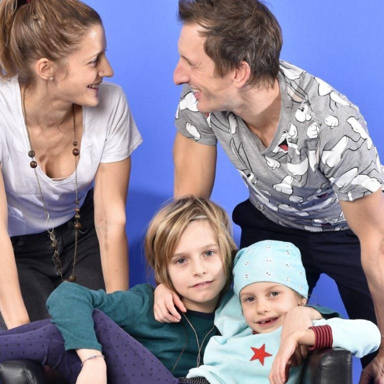 Familienfoto auf Sofa blauer Hintergrund